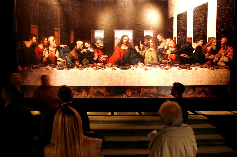 Varias personas observan una copia de la famosa obra de Leonardo da Vinci "La última cena".