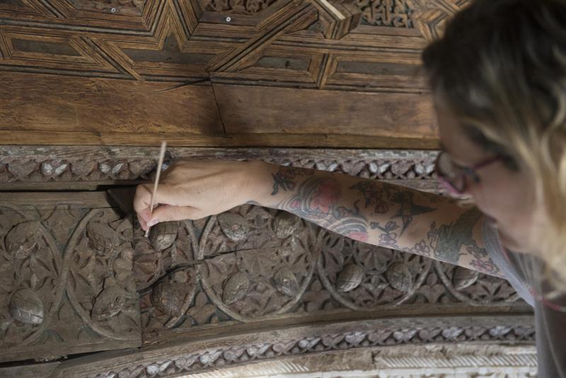 Una restauradora trabaja en la cúpula del templete oriental del Patio de los Leones.